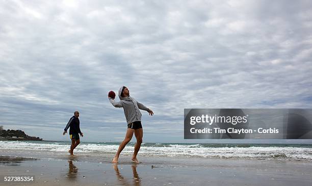 Quade Cooper throws an Aussie Rules Sherrin football during the Australian teams recovery session at Takapuna Beach at the IRB Rugby World Cup...
