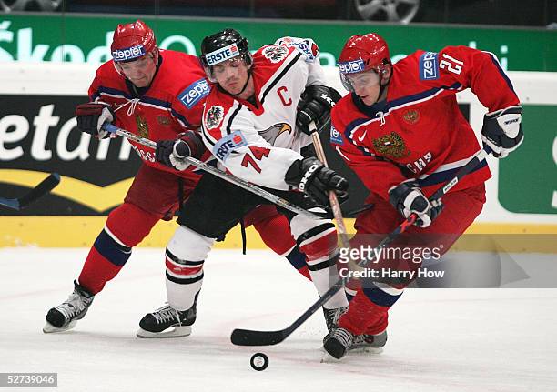 Andrey Markov and Alexander Kharitonov of Russia squeeze Dieter Kalt of Austria during the IIHF World Men's Championships preliminary round game at...