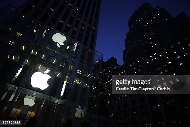 The Apple Logo, on the glass fronted Apple Store, surrounded by the high rise buildings of Manhattan opposite Central Park on Fifth Avenue,...