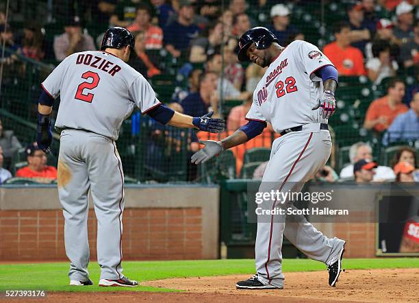 Brian Dozier and Miguel Sano of the Minnesota Twins celebrate after Sano scored a run in the fifth inning of their game against the Houston Astros at...