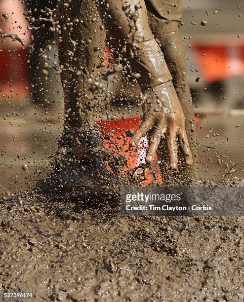 Feet with mud flying as competitors emerge from the mud pit during the New York Merrell Down and Dirty Obstacle Race presented by Subaru. Over 6000...