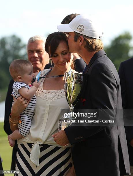 Kevin Streelman kisses his wife, Courtney, who is holding their 6-month-old daughter, Sophia, after winning the Travelers Championship at the TPC...