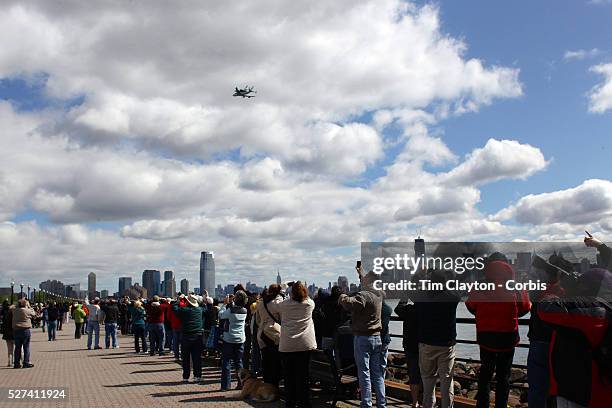 Onlookers in Liberty State Park, New Jersey as the NASA space shuttle Enterprise, riding on top of a modified jumbo jet, flying at low altitude past...