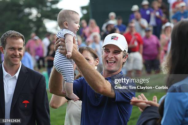 Kevin Streelman holding his 6-month-old daughter Sophia, watched by his wife Courtney after winning the Travelers Championship at the TPC River...