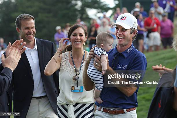 Kevin Streelman holding his 6-month-old daughter Sophia, watched by his wife Courtney after winning the Travelers Championship at the TPC River...