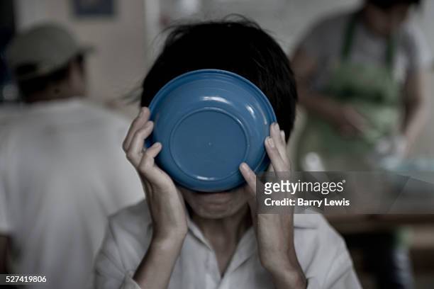 Woman drinks the last of a bowl of soup at a soupt kitchen in the poorest area on the edge Ulaanbaatar. The kitchen was set up by local Buddhists.