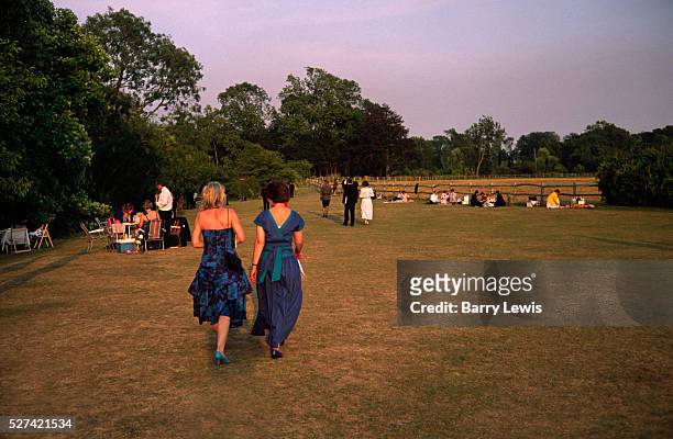 Two ladies wear evening dresses during a warm summer evening.