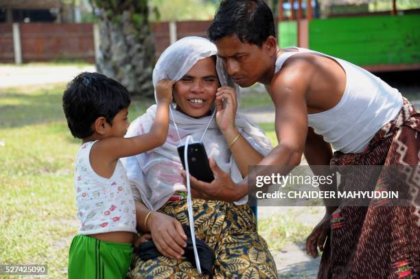 This picture taken on March 27, 2016 shows a Rohingya family doing a video call with their family at the Rohingya housing complex in Bayeun in East...