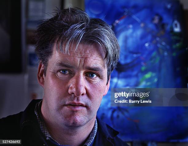 Anton Meenan, one of Tory Island's celebrated painters at the Dixon gallery in front of one of his paintings.