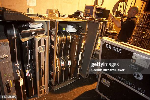 Roadie belonging to the crew of British rock and roll band Status Quo starts packing up sound equipment and the guitars of Rick Parfitt and Francis...