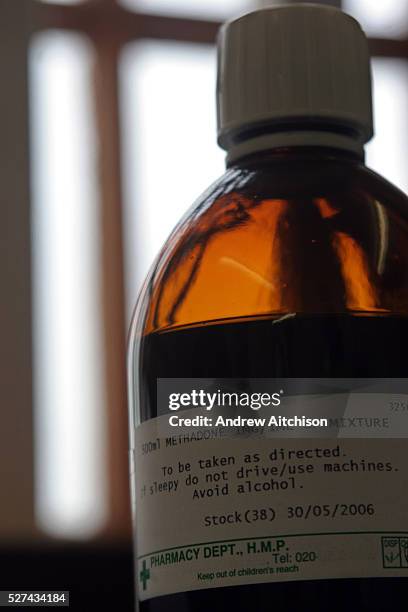 Bottle of Methadone mixture stands on the window sill in front of the bars in the prison pharmacy.