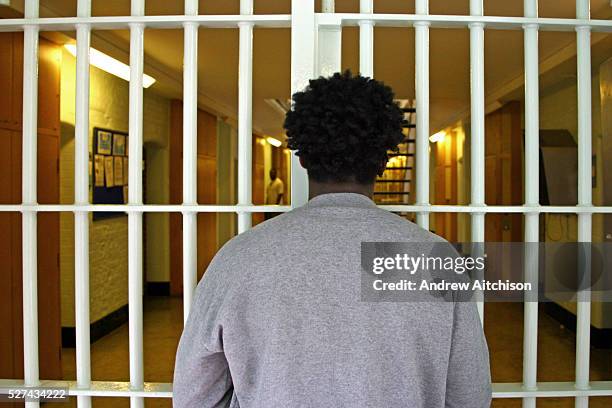 Young black male prisoner waits at a security partition gate in the D wing of Wandsworth prison. HMP Wandsworth in South West London was built in...