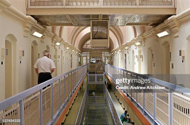 Prison officer walks down the C wing at Wandsworth prison. HMP Wandsworth in South West London was built in 1851 and is one of the largest prisons in...