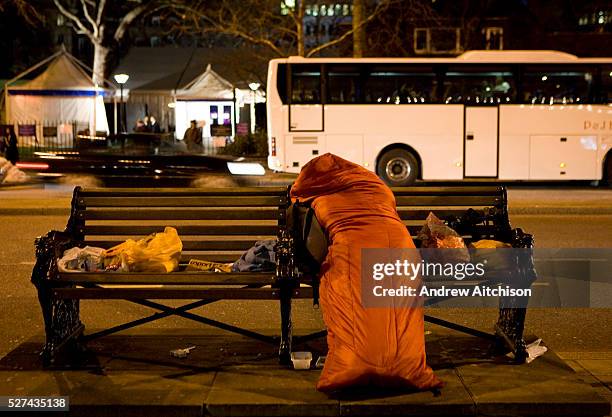 Homeless woman sleeps in her sleeping bag on Victoria Embankment, London.