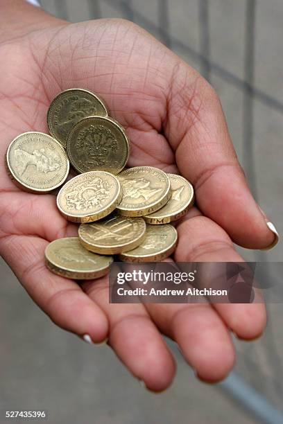 British pound coins in the palm of woman's hand.