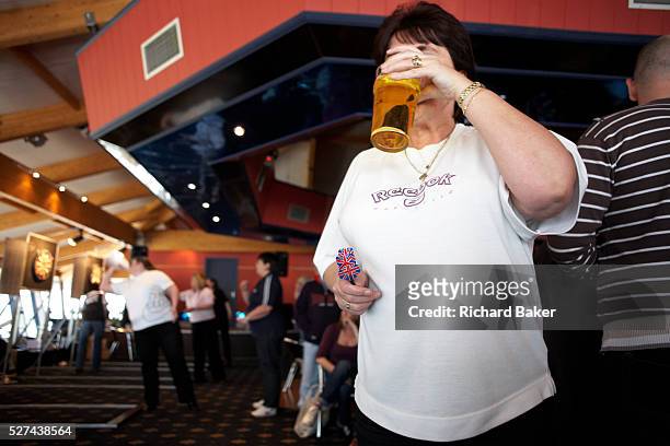 Large, manly woman sips a pint of lager during a darts tournament where she competes in an England Open tournament at the Bunn Leisure Holiday Park...