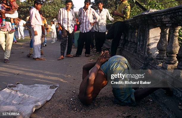 Holy Sadhu man attracts a crowd on the Maidan in central Calcutta, India. Near some ballustrades built by the British during the last years of the...