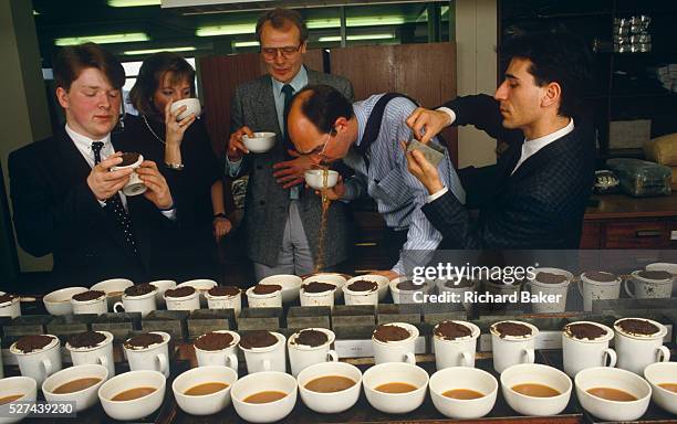 Team of English tea-tasters employed by the tea company Lyons sample different blends for the PG Tips brand in the City of London, England UK. With...