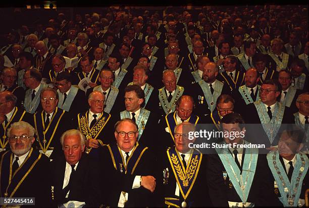 "Assembled Freemasons watch a masonic ceremony at Earls Court, London. Freemasonry, which traces it's modern origins back to the sixteenth century is...