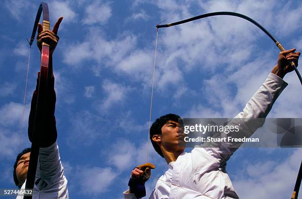 Young Kyudo practitioners practice outside before a competition at the Kyoto Budo Centre dojo. Kyudo is a modern Japanese martial art derived from...