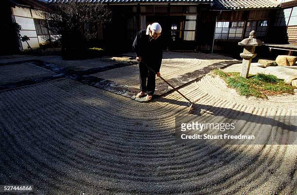 Zen monk of the Soto School rakes a sand garden as part of meditative practice at the Seiryu-ji Temple in Hikone City.