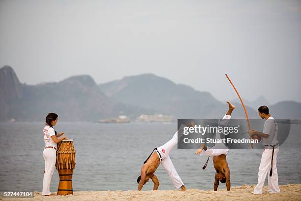 Capoeiristas practice Capoeira on Flamengo beach. Capoeira is a mixture of martial arts, games, and dance that originated in Brazil created and...