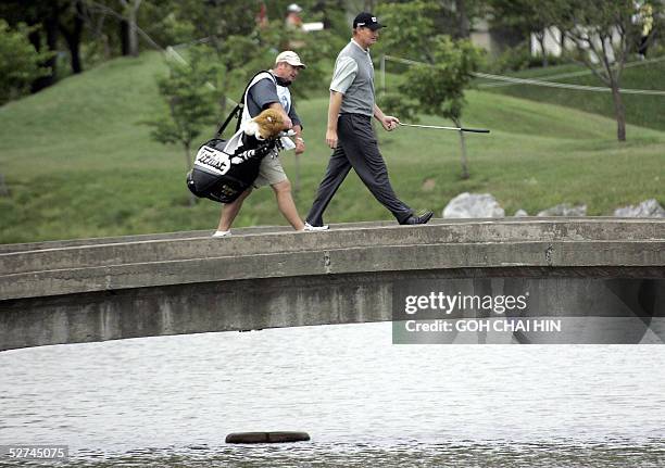 World number three Ernie Els of South Africa and his caddy make their way across a bridge during the final round of the 1.5 million USD BMW Asian...