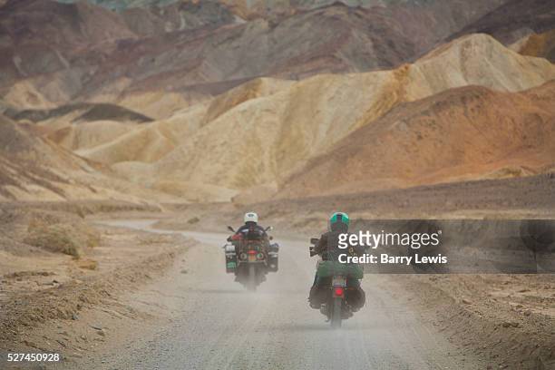 Motorbikes with camping gear on 20 mule team road in Death Valley National Park in California, noted for its erosional landscape and being one of the...