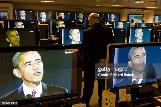 Live BBC news is being broadcast on TV screens in the John Lewis department store in Oxford Street, London, England. A newly-elected Barack Obama is...