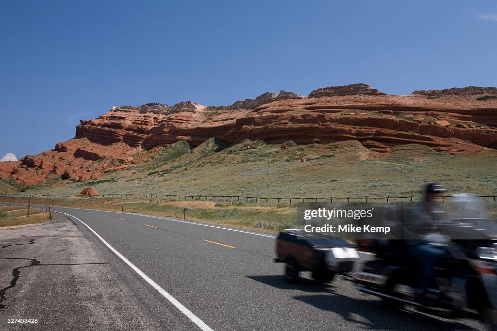 USA - Wyoming - Harley Davidson passes sandstone outcrop
