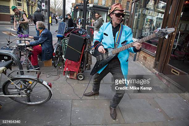 Rock band comprised of middle aged men, street busking and entertaining people on Brick Lane London, UK. The bass player wearing a blue Teddy Boy...