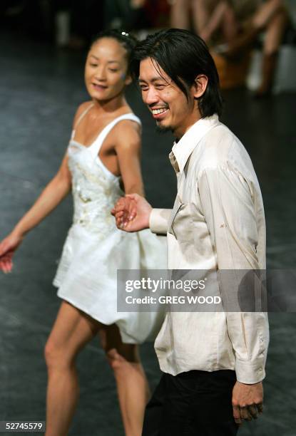 Dancer from the Sydney Dance Company , wears a creation by Australian designer Akira Isogawa , who acknowledges the applause of guests following his...