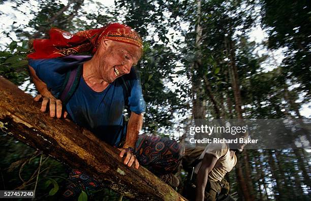 Grinning from ear to ear, young volunteers throw themselves over a fallen tree during a strenuous activity on a Raleigh International expedition in...