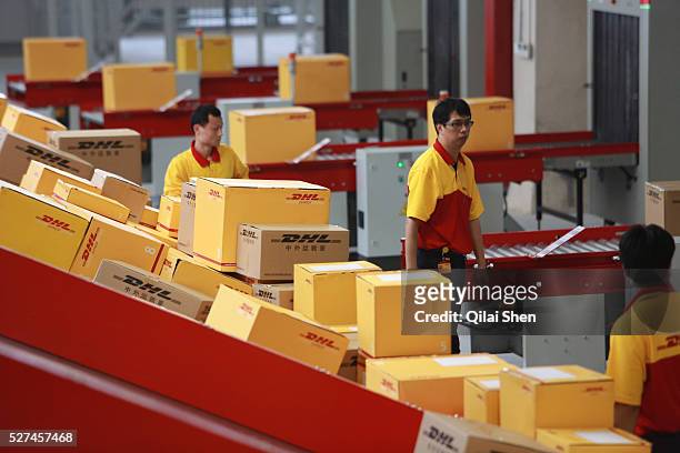 Employees sort and move boxes at the newly opened Deutsche Post DHL North Asia Hub in Shanghai, China on 12 July 2012. DHL is expecting its business...