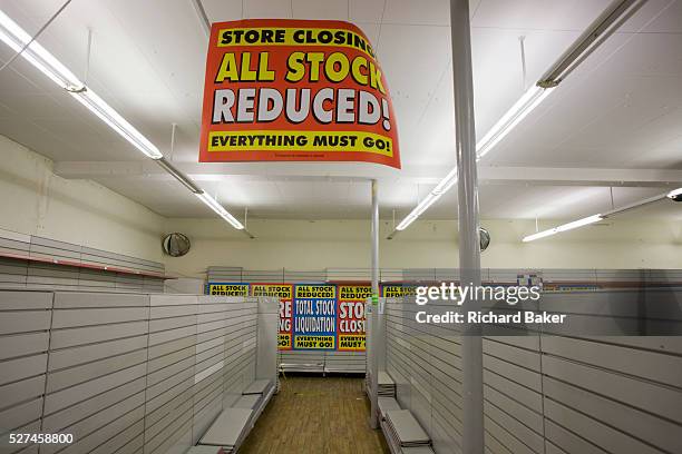 On the last day of trading, surrounded by empty shelves and shop fittings, sheets of closing down posters are seen lying on the shop floor in the...
