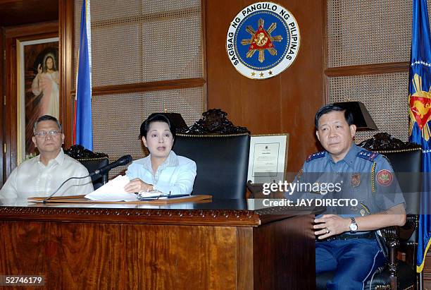 Philippine President Gloria Macapagal Arroyo flanked by Interior and Local Government Secretary Angelo Reyes and National Capital Region Police Chief...