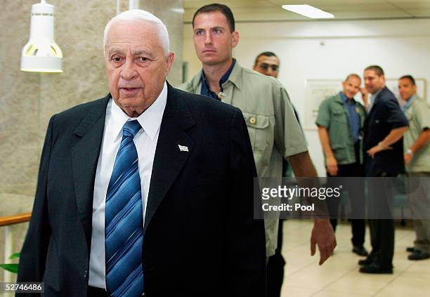 Prime Minister Ariel Sharon walks through the halls of his Jerusalem offices with security agents on the way to chair a cabinet meeting on May 2,...