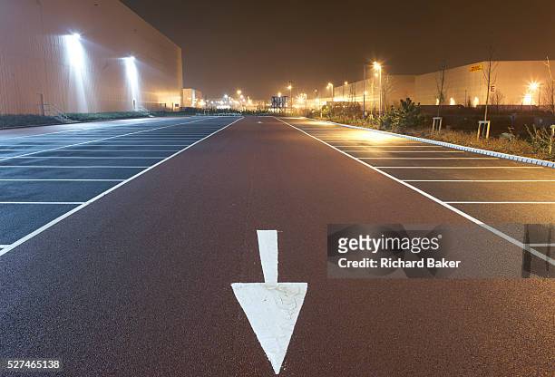 Pointing towards the viewer and the bottom of the picture near empty parking bay markings, a stencilled arrow directs traffic flow at the DIRFT...