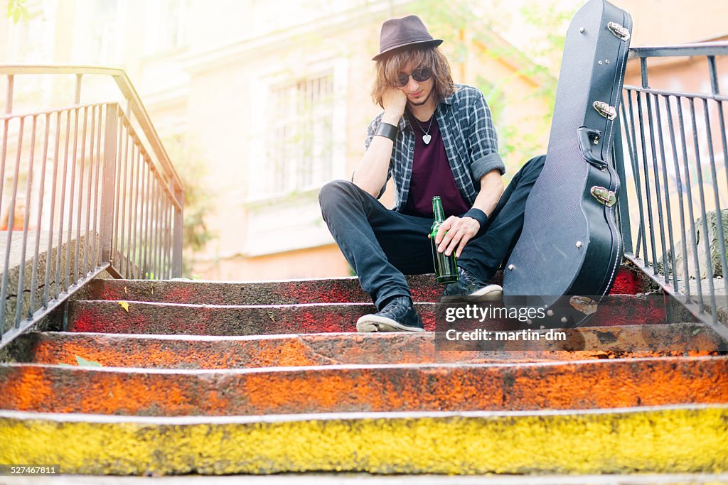 Street musician with beer outside