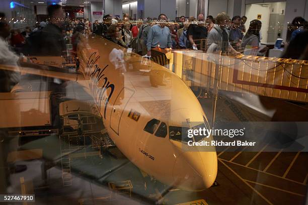 About to board their Sri Lankan airlines flight to the Maldives, crowds of economy class passengers stand and make an orderly queue when their flight...