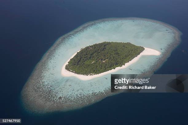 An aerial view of a completely uninhabited, deserted island seen from a regional aircraft passing overhead atolls and islands, an hour's flying time...