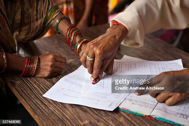 Signing the paper work. A woman from a rural slum in the Orissa district of India gets legal advice and birth certificates from a Legal Aid Clinic...