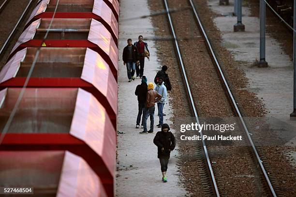 Migrants walk along the railway track leading to the EuroTunnel at night, in Calais, France, August 10, 2015. Migrants are attempting to enter the...