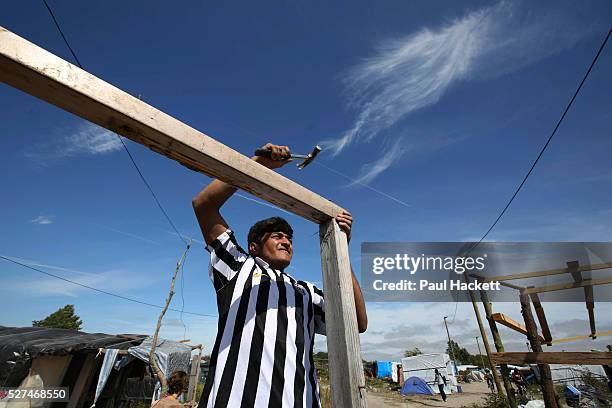 Man builds the beginnings of a hut at 'the Jungle' migrant camp in Calais, France, August 10, 2015. The Calais jungle is the nickname given to a...