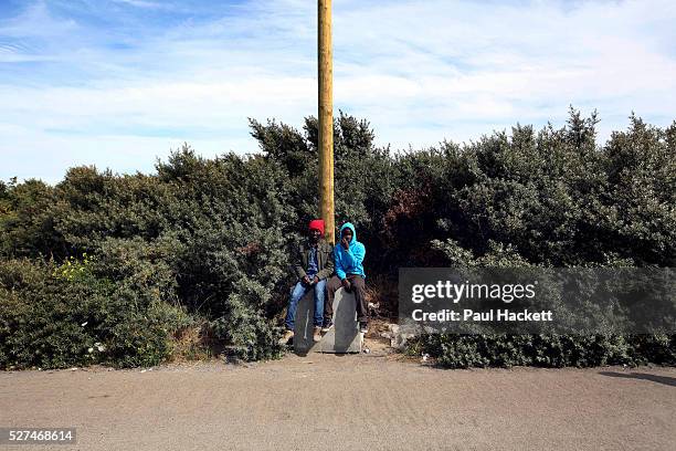 Men sit at 'the Jungle' migrant camp in Calais, France, August 10, 2015. The Calais jungle is the nickname given to a series of camps in the vicinity...