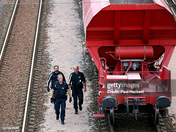 Migrants walk along the railway track leading to the EuroTunnel at night, in Calais, France, August 10, 2015. Migrants are attempting to enter the...
