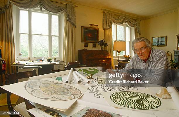 The renowned maze designer Randoll Coate works in his studio on more labyrinth plans. Gilbert Randoll Coate was a British diplomat, maze designer and...