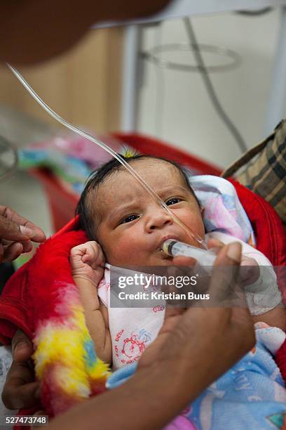 Health worker Santina feed 1 day old Maria colostrum milk collected from her mother, Flaviana. Flaviana gave birth to baby girl Maria the day before...