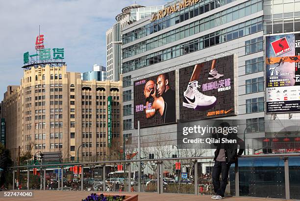 Man takes a picture with his cellphone while standing in People's Park near the Nanjing Road pedestrian shopping street in downtown Shanghai, China...