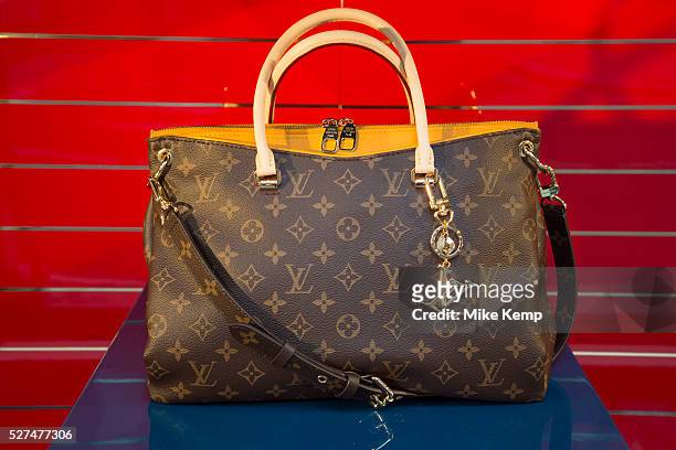 Bag in the shop window of Louis Vuitton store in the City of London, UK. Louis Vuitton Malletier, commonly referred to as Louis Vuitton or shortened...